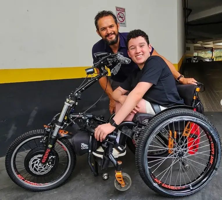 Cliente e familiar com o Kit Livre acoplado à cadeira de rodas